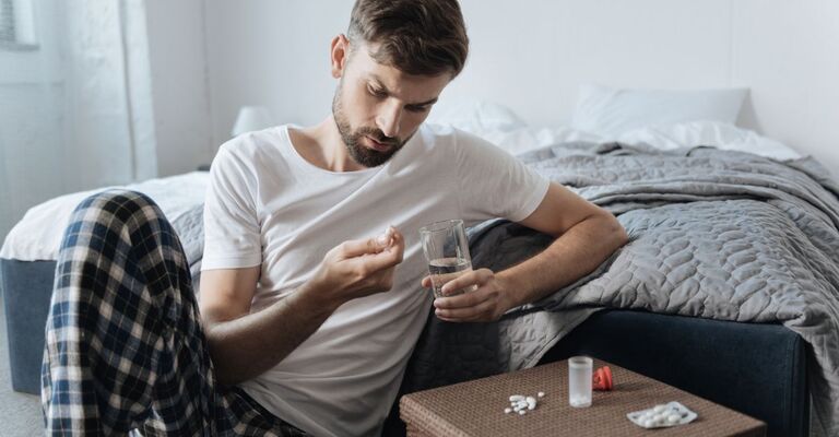 uomo triste prende farmaco