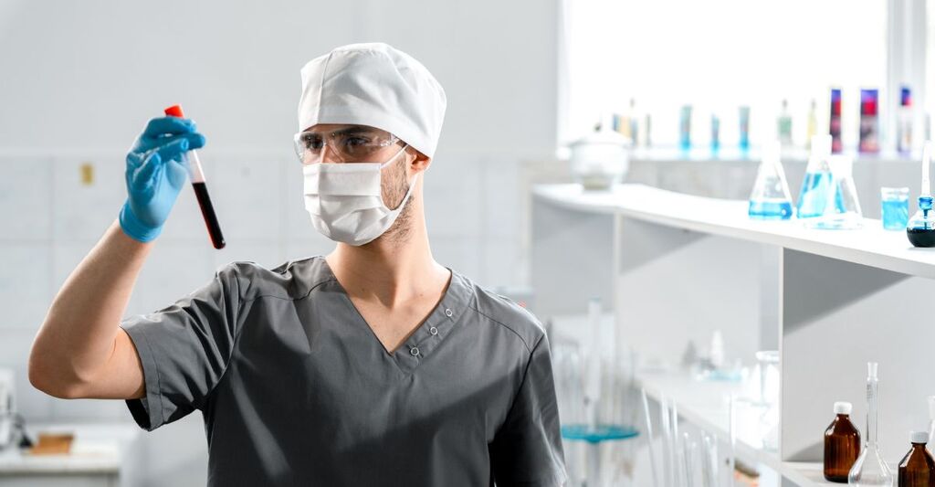 Un medico con una provetta di sangue in mano