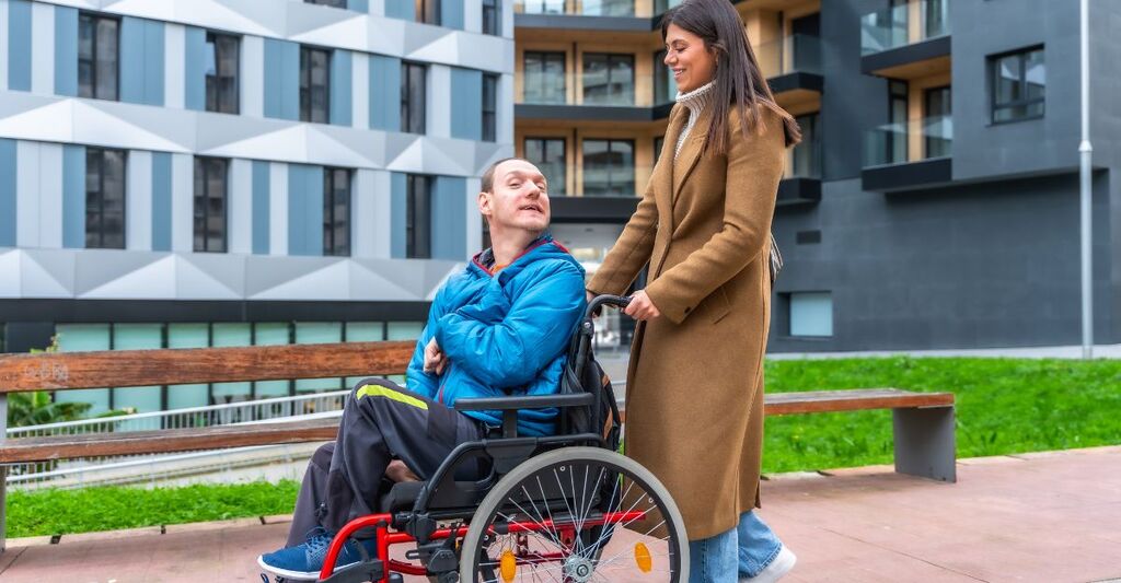 Una persona che spinge la carrozzina di un paziente invalido