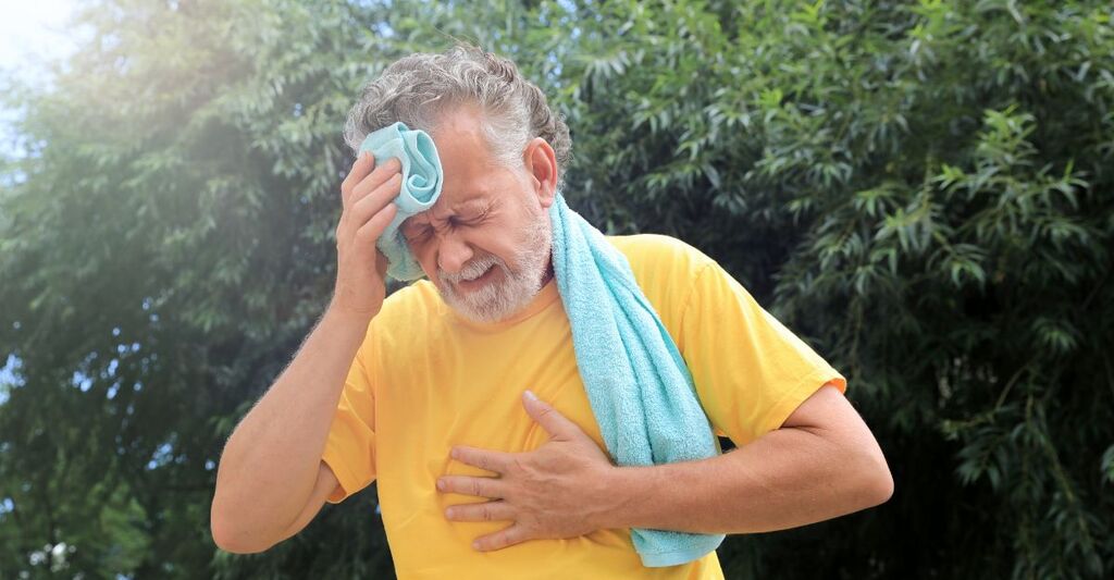 uomo accaldato si asciuga la fronte con l'asciugamano