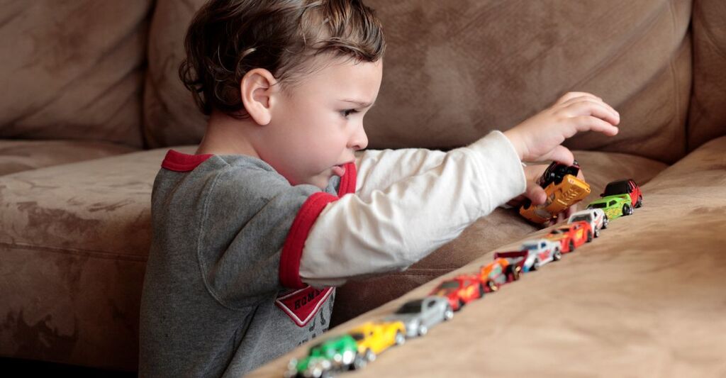 Un bambino piccolo che gioca con le macchinine