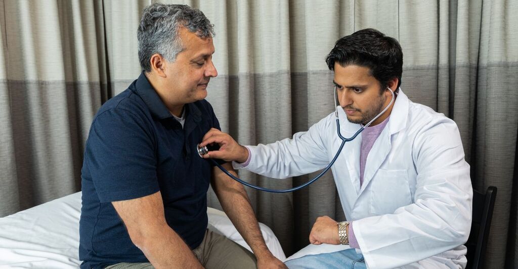 Un medico che ausculta il petto di un paziente