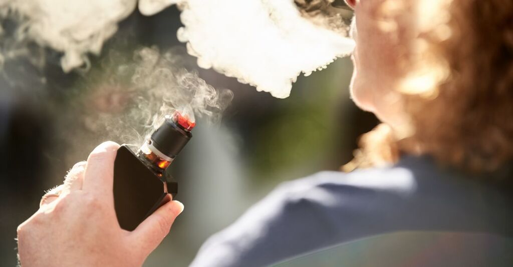 Una persona che svapa da una sigaretta elettrica
