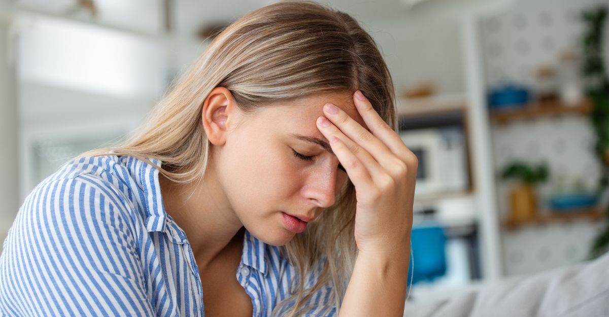Una ragazza si tiene la testa dolorante