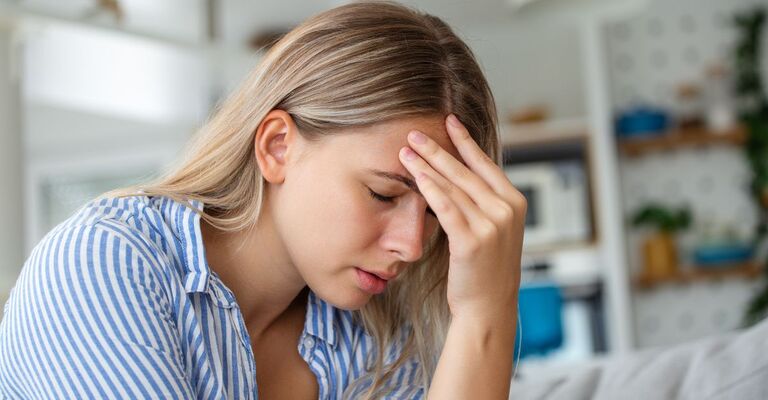 Una ragazza si tiene la testa dolorante