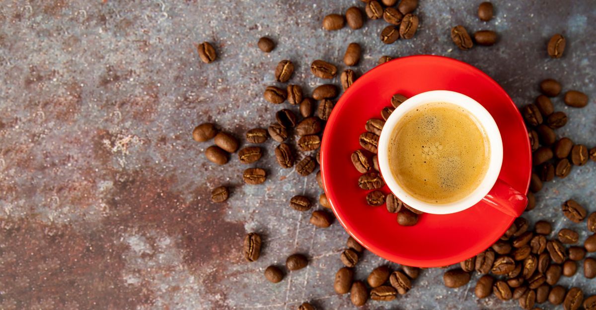 tazzina da caffè sul tavolo, con chicchi di caffè sparsi