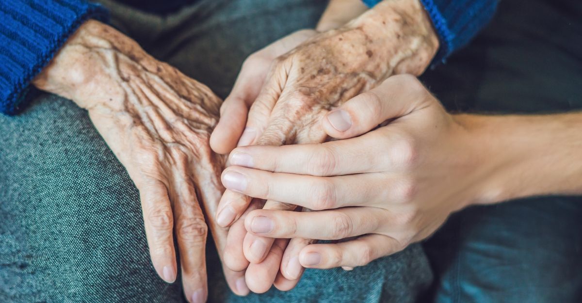 La mano di una persona che stringe una mano di una persona anziana