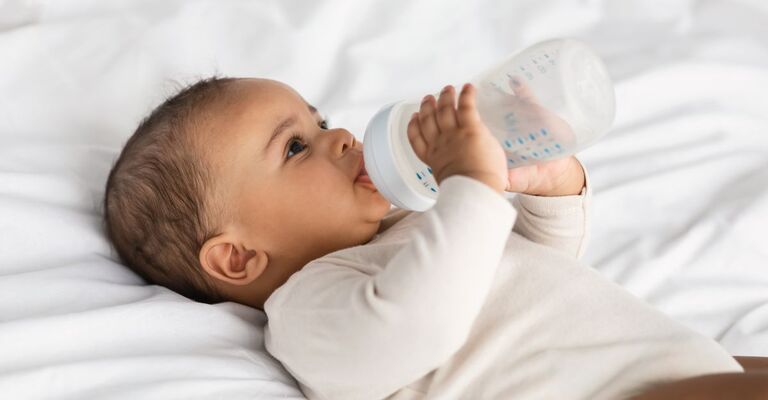 Un neonato che beve dal biberon