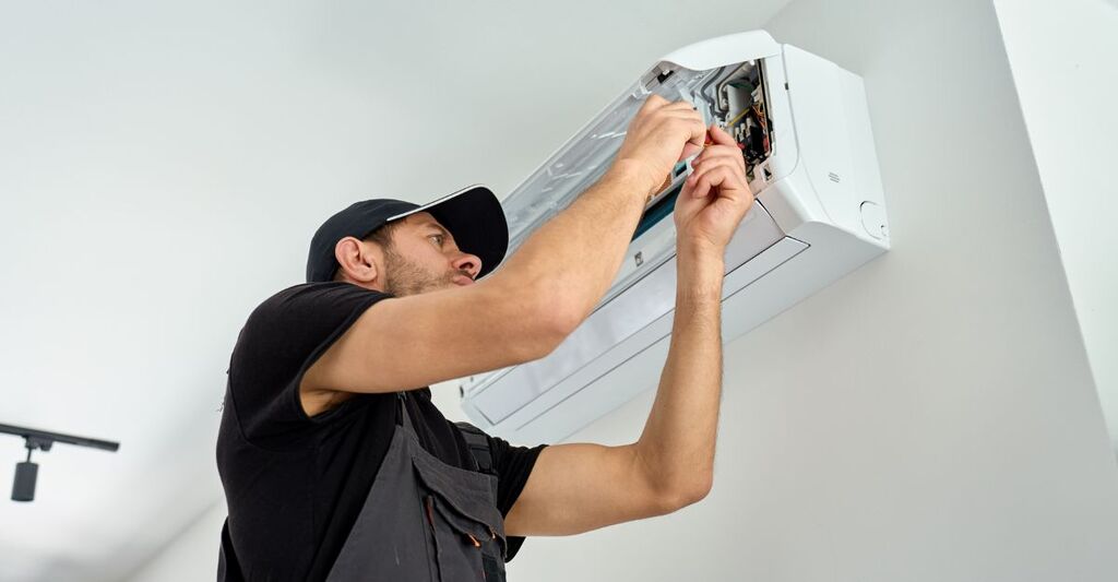Un tecnico che pulisce un condizionatore