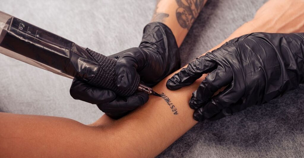 Un tatuatore che fa un tatuaggio ad una persona