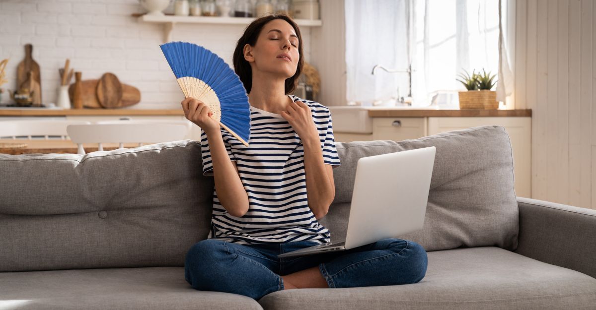 Una signora accaldata che si fa aria con un ventaglio