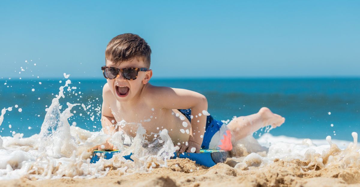 Un bambino in spiaggia con occhiali da sole