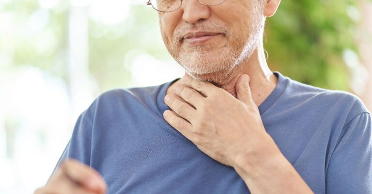 Un uomo si tocca il collo infastidito