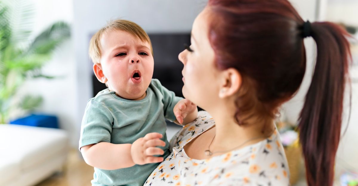 Un bambino che tossisce in braccio alla madre