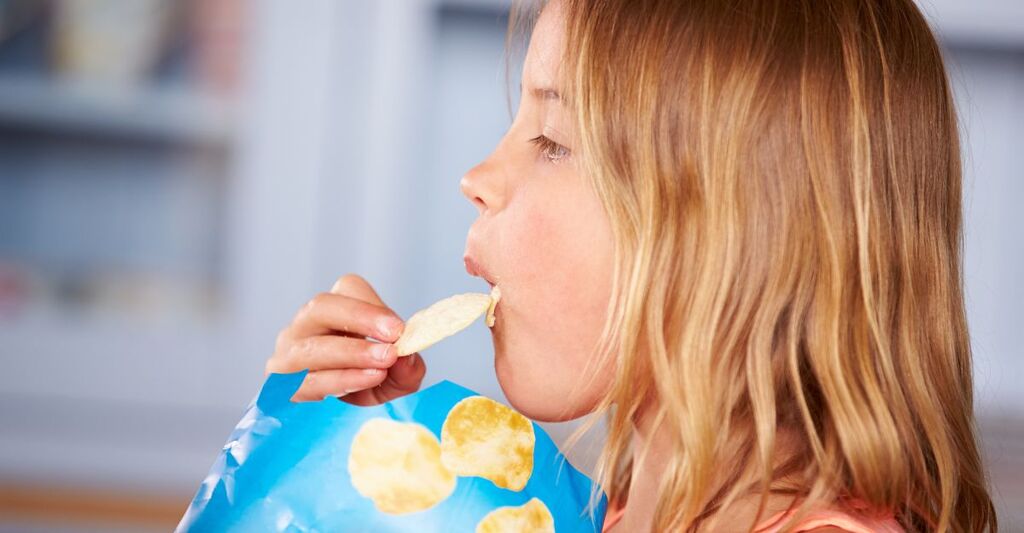 bambina mangia patatine