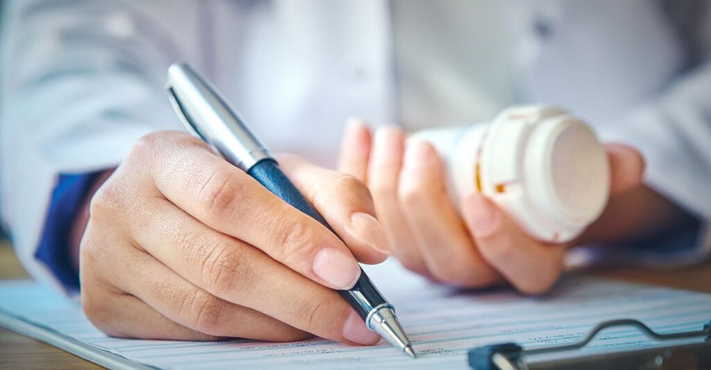 Un medico che compila una ricetta