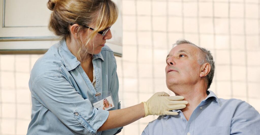 Un medico visita la gola di un paziente