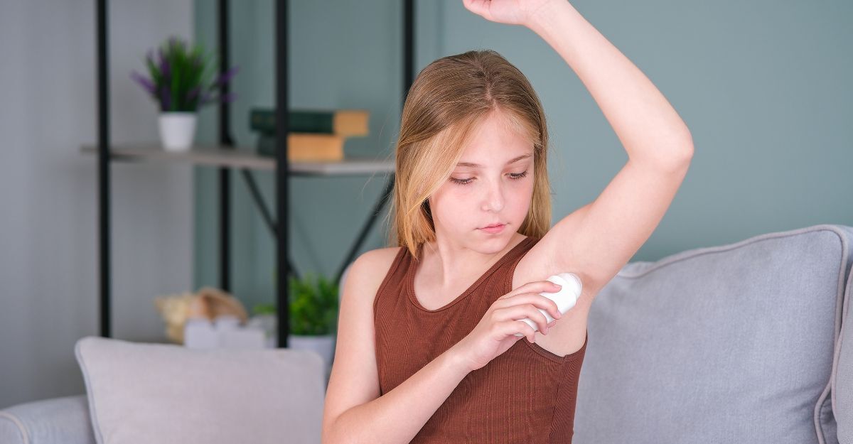 bambina si applica il deodorante