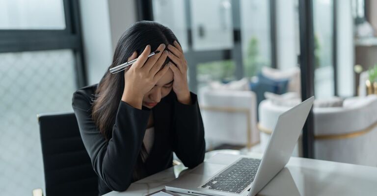 Una donna alla scrivania disperata per il suo lavoro