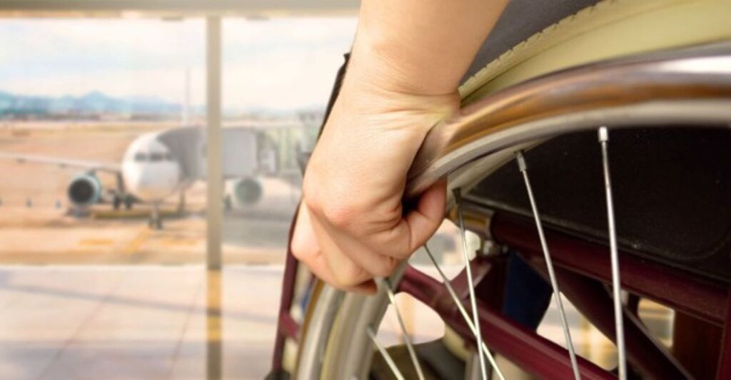 Una persona in sedia a rotelle che si appresta a prendere una aereo