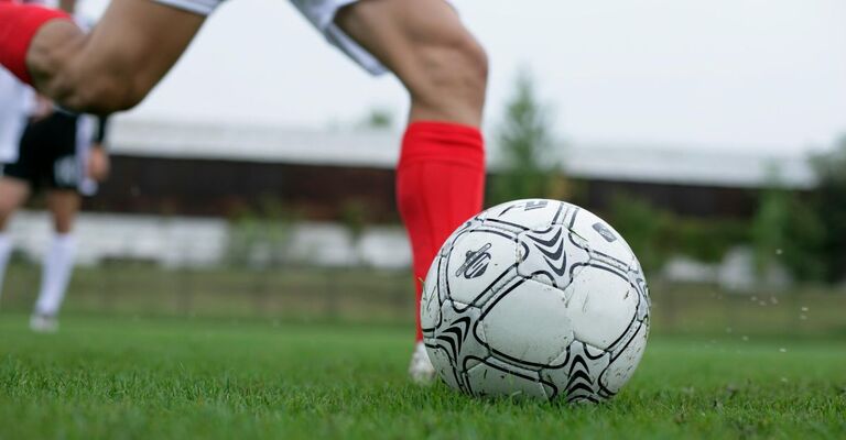 gambe di giocatore che gioca a calcio