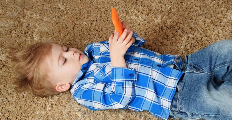 Un bambino che gioca con una carota