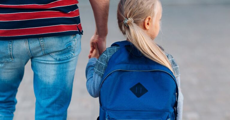 Un genitore accompagna la figlia a scuola
