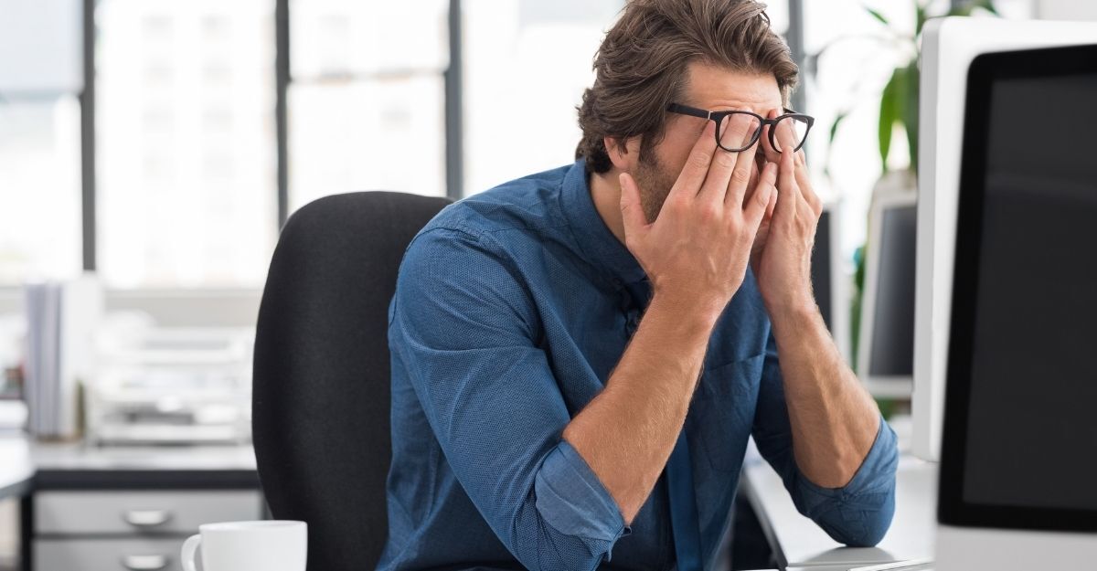 Un uomo stanco al computer in ufficio