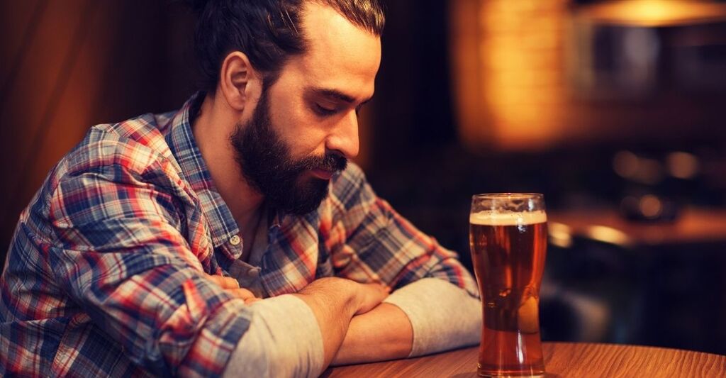 persona sola, beve una birra la bancone del bar