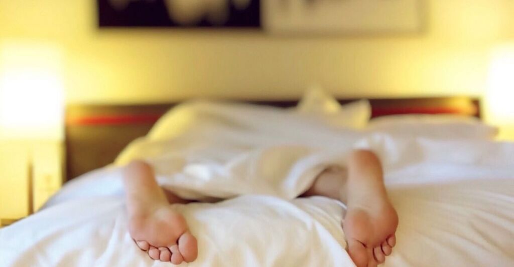 Persona sdraiata a letto durante una notte insonne