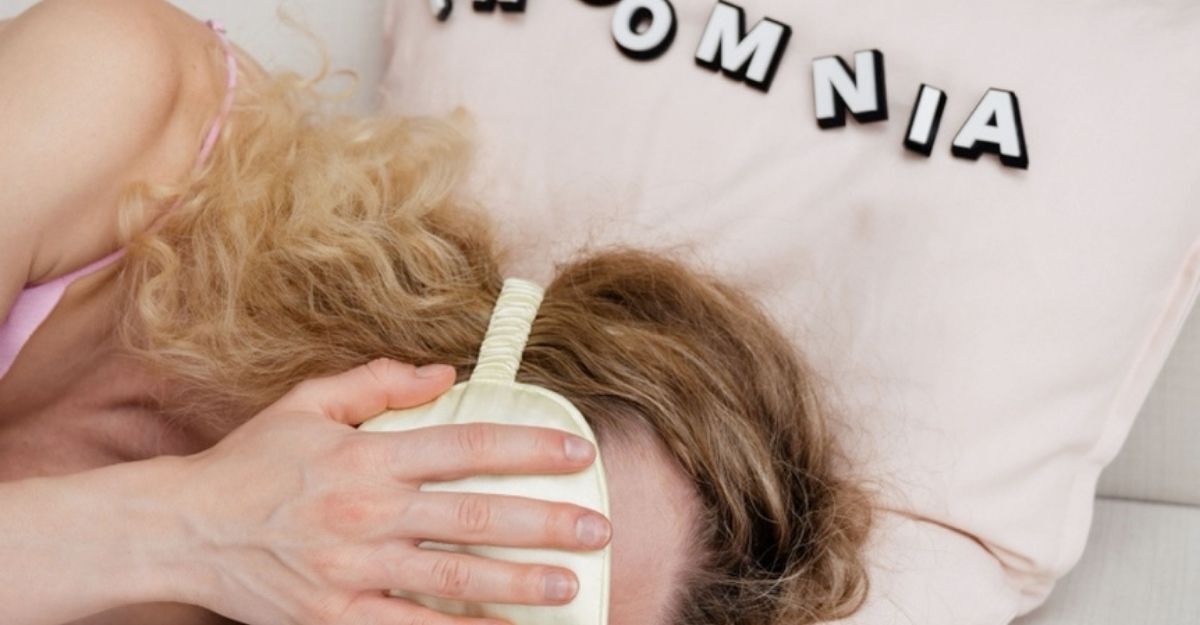 Persona con difficoltà a dormire a letto, con le mani sul viso