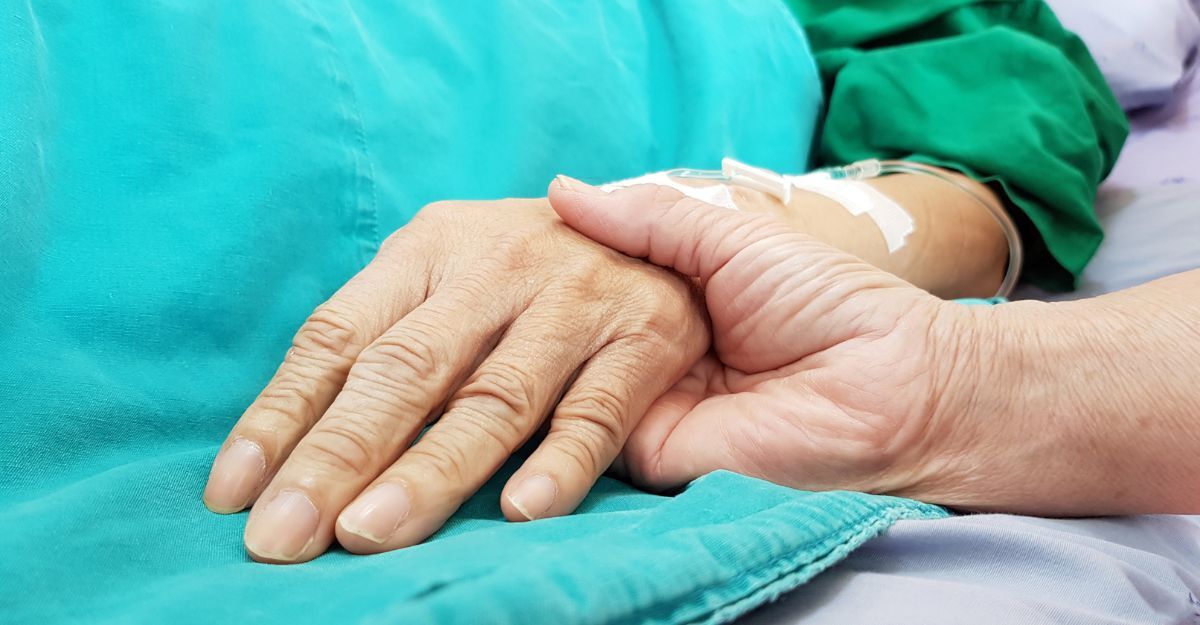 Una donna che tiene la mano di una signora anziana malata
