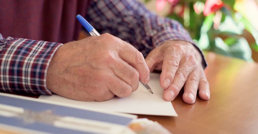 Un signore anziano che disegna su un foglio