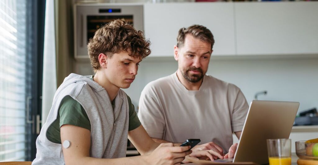 ragazzo col diabete al pc con un altra persona seduta a fianco