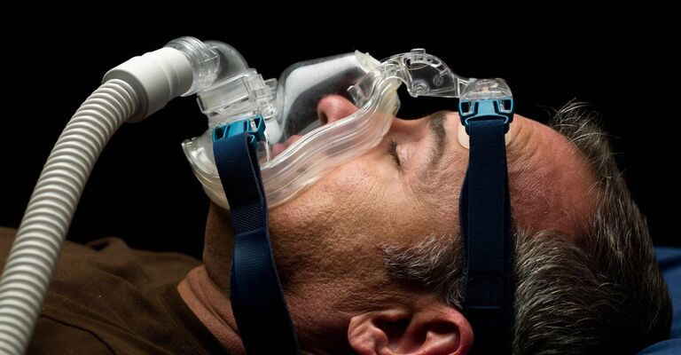Un uomo che dorme con una maschera cpap