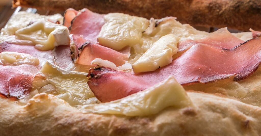 Una pizza con speck e brie