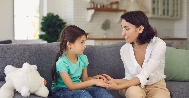 adulto che parla ad un bambino, seduti sul divano