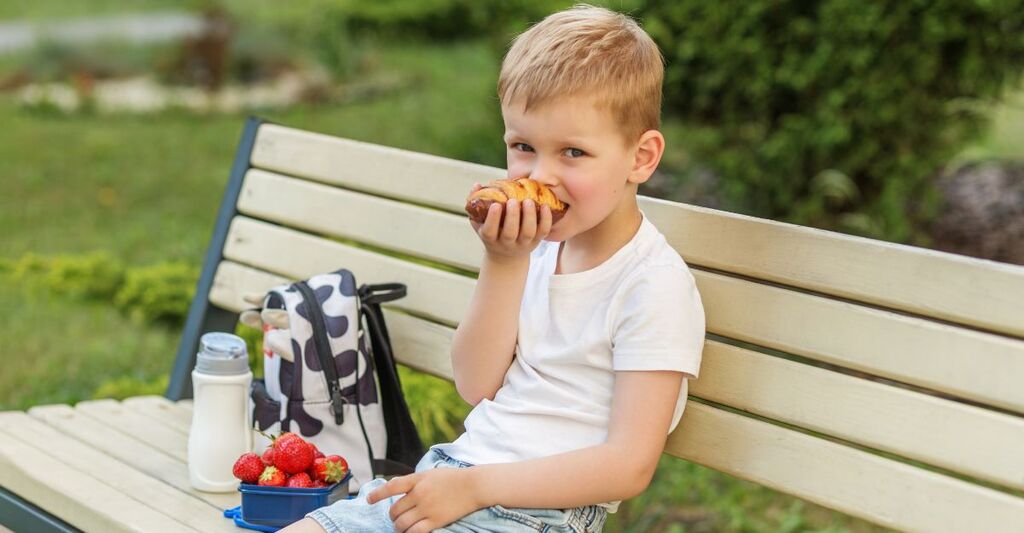 Un bambino che fa merenda