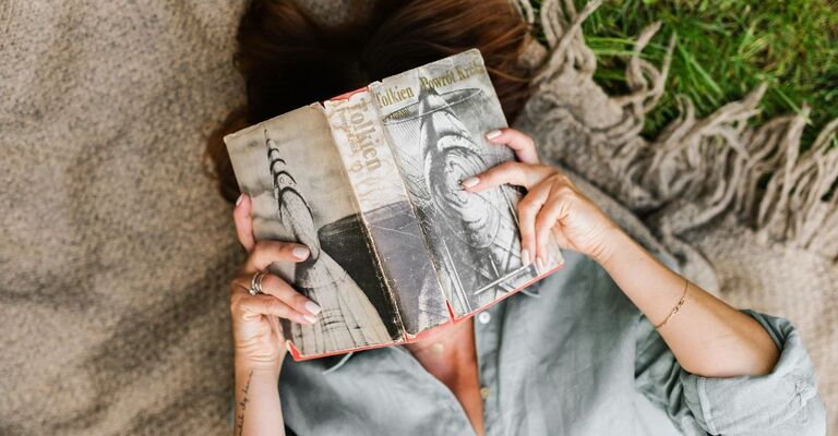ragazza legge un libro sul prato