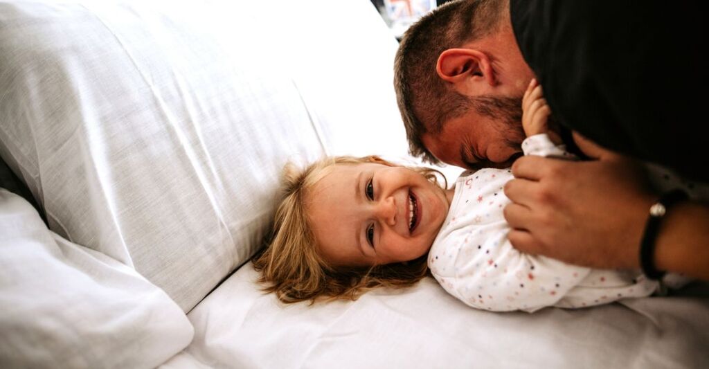 padre che coccola la figlia sul divano
