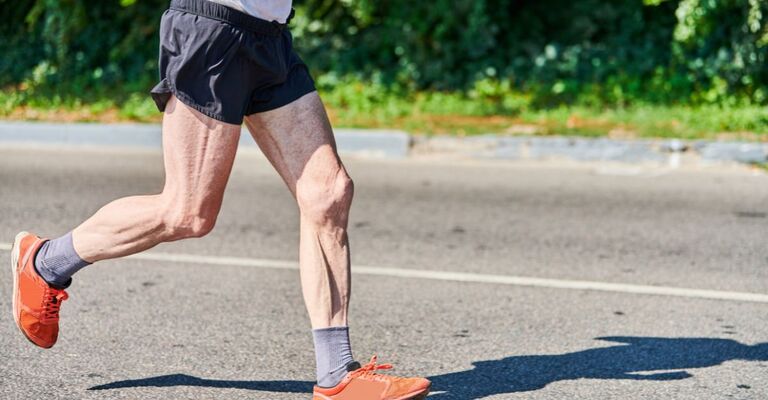 Le gambe di una persona anziana mentre corre