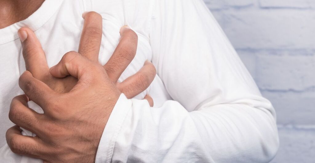 Persona che si stringe il petto con le mani all'altezza del cuore per un improvviso dolore al torace