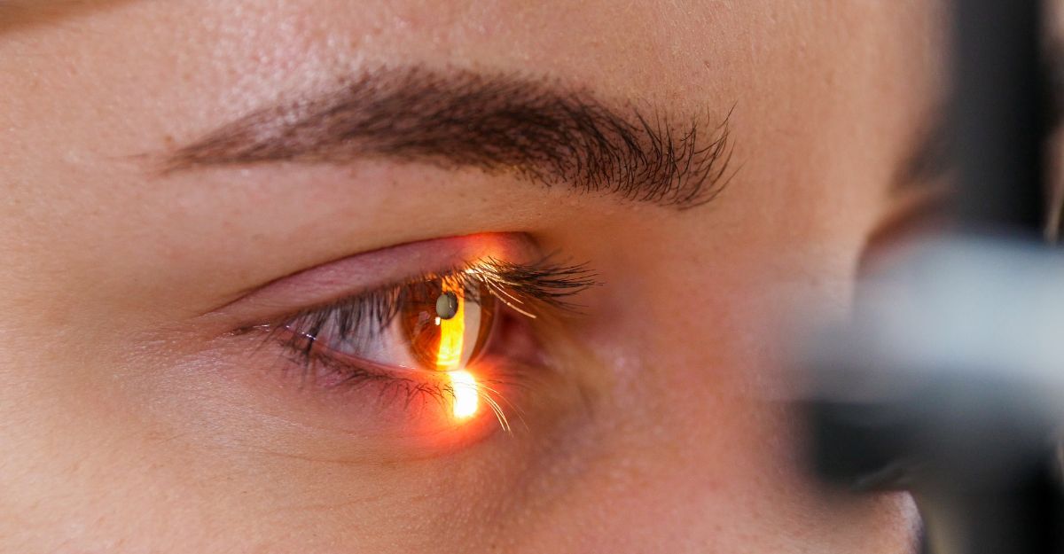 Primo piano di un occhio umano sottoposto a una visita oculistica, illuminato dalla luce di una lampada a fessura per l'esame della retina e della cornea