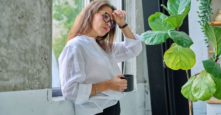 donna avverte una vampata mentre ha una tazza in mano