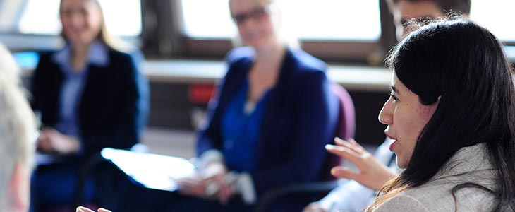 730x300 - Frau spricht vor Gruppe im Stuhlkreis