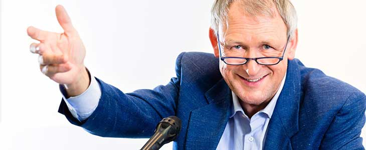 730x300 l&auml;chelnder Mann mit ausschweifender Gestik