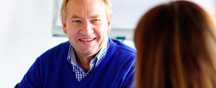 730x300 l&auml;chelnder Mann im Gespr&auml;ch