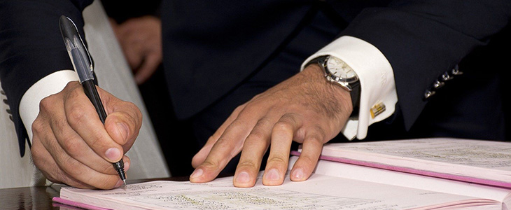 730x300 M&auml;nnerh&auml;nde mit  Stift schreiben in eine Mappe