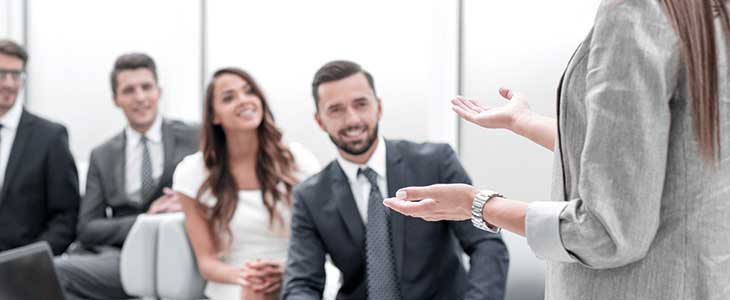 730x300 Frau - nur Teile sichtbar - redet vor Gruppe