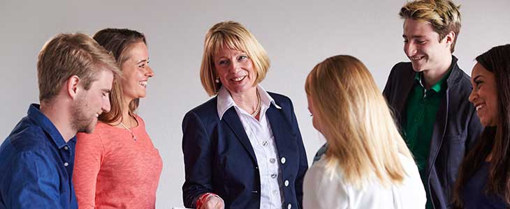 730x300- lachende Gruppe junger Menschen mit &auml;lterer Frau